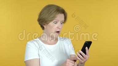 黄背景下的老女人失物招领使用智能手机